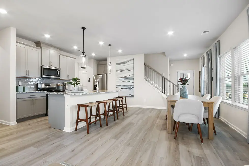 Open-plan kitchen, dining and staircase with a gallery wall and large windows, photographed for a listing near Social Circle